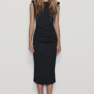 Round neck sleeveless midi dress with shoulder pads. Open back detail